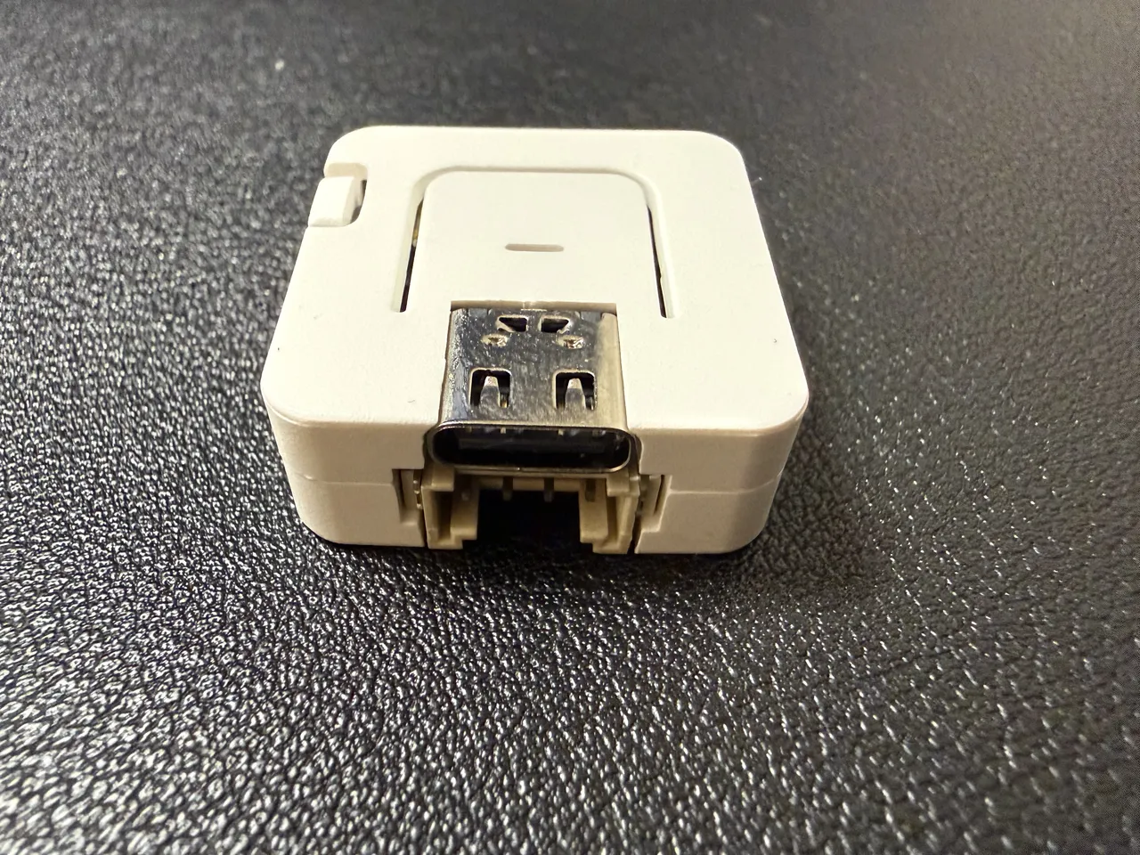白い小さな四角いマイコン ATOMS3 Lite。手前に USB Type-C の端子と、下側に Grove の端子が見える